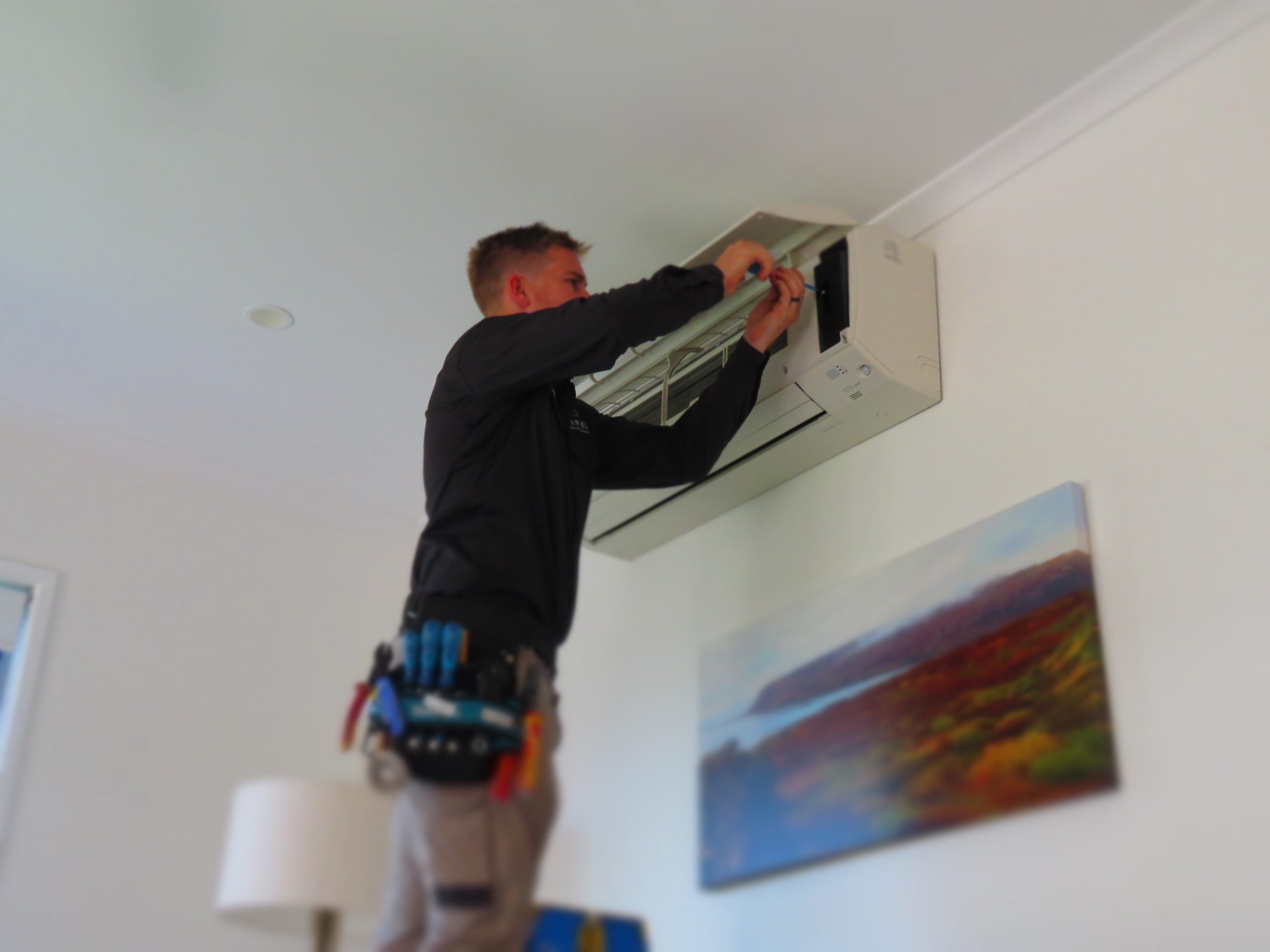 man repairing split system air conditioner