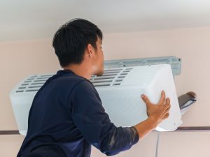 man installing a spit system air conditioner