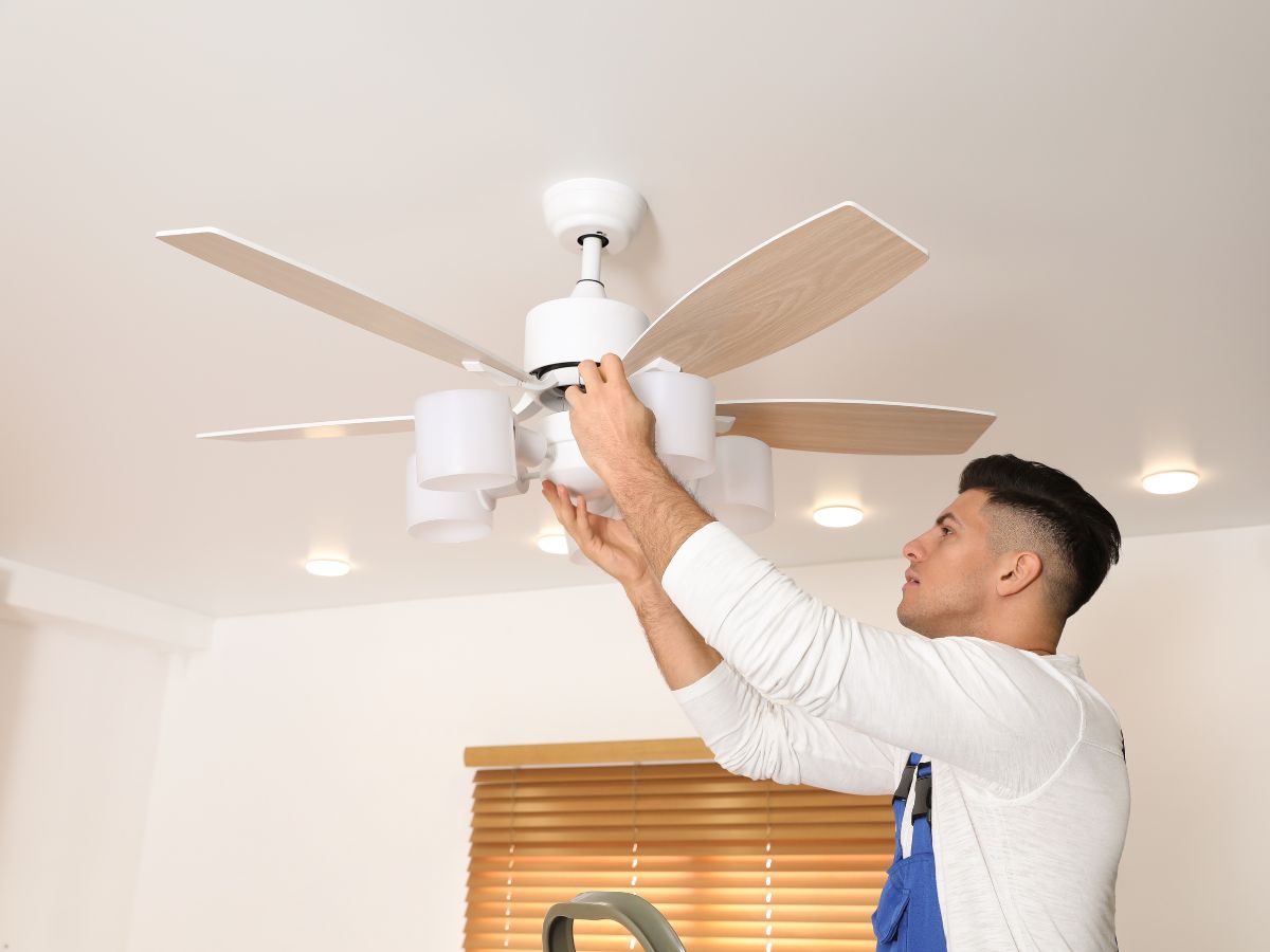 man installing a ceiling fan