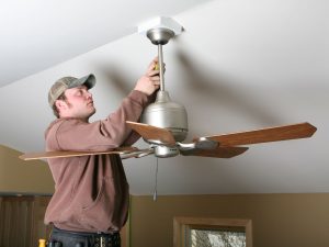 man installing a fan on a vaulted ceiling